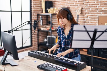Fototapeta na wymiar Young woman musician playing piano keyboard at music studio