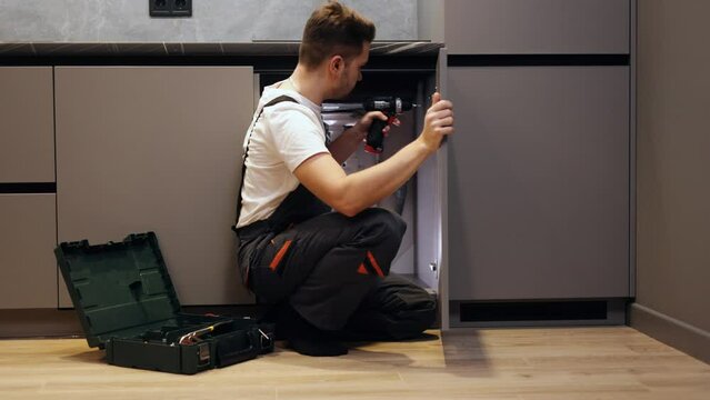 A furniture maker adjusts and assembles furniture. the master assembles furniture for the kitchen.