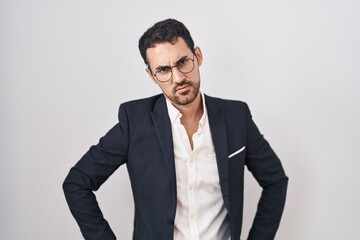 Handsome business hispanic man standing over white background skeptic and nervous, frowning upset because of problem. negative person.