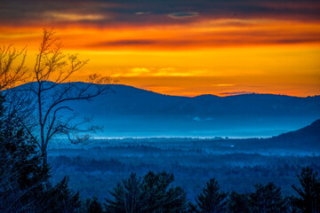 Fototapeta na wymiar Orange sunrise over foggy mountains 