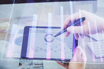 Double exposure of man's hands holding and using a phone and financial chart drawing. Market analysis concept.