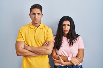 Obraz premium Young couple standing over isolated background skeptic and nervous, disapproving expression on face with crossed arms. negative person.
