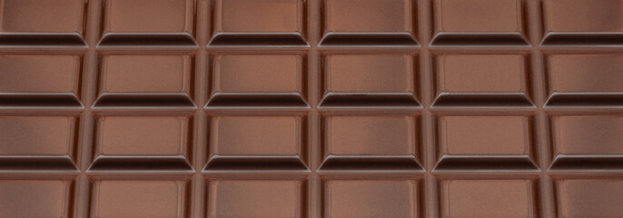 Dark Milk chocolate bar as a background. Flat lay, top view. Sweet chocolate food Pattern.