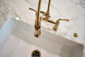 Looking down into kitchen sink with gold faucet soft focus - 570932205