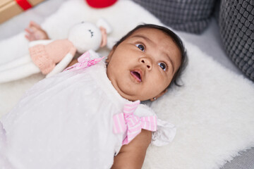 African american baby lying on bed with relaxed expression at home