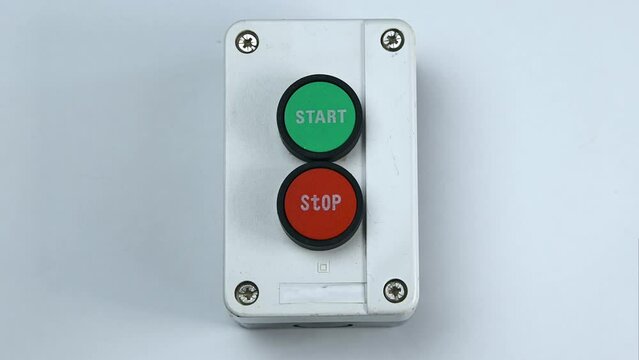 The finger presses the stop button. Two buttons in the case, green - start switch, red - stop switch
