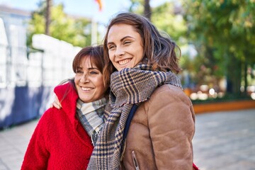 Two women mother and daughter hugging each other at park