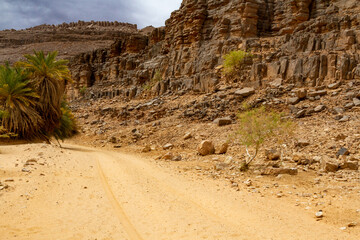 Oued Aharhar Gorge. Dirt road among the rocks. Tadrart mountains. Aharghar Canyon, Tadrart mountains, Tassili n'Ajjer National Park, Illizi Province, Djanet, Algeria, Africa   