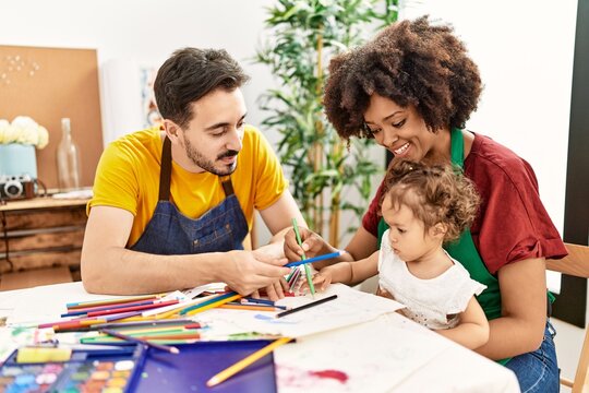 Couple and daughter smiling confident drawing at art studio