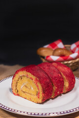 Brazo de Reina, red roll,  on wooden table on black background