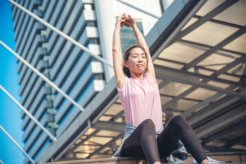 Sport Fitness Woman stretching body exercise in modern city wear wellness sportswear outside. Young woman workout outdoor exercising on bright sunny outside. Healthy wellness lifestyle woman concept.