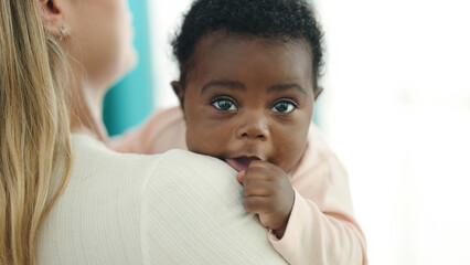 African american baby on mother arms at home