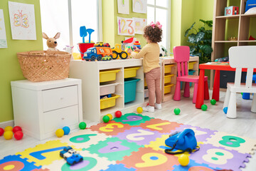 Adorable hispanic toddler playing at kindergarten