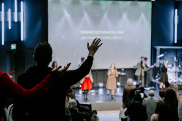 Hands in the air of people who praise God at church service - 570944216