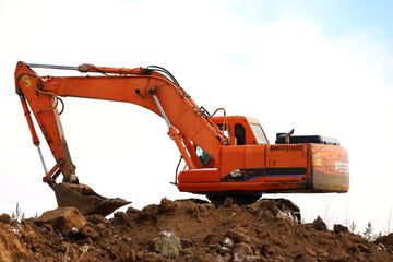 Crawler excavator scoops the earth with a bucket. Earthmoving works, digging and construction industry