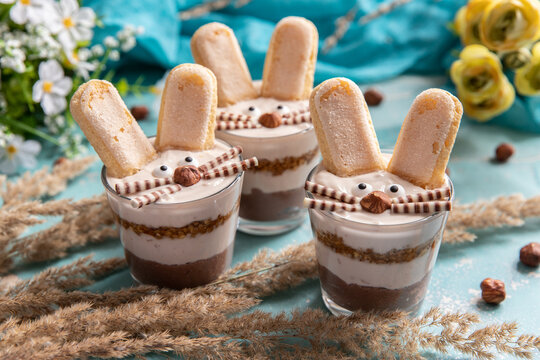 Hase im Glas geschichtet als Dessert zu Ostern auf blauem Hintergrund