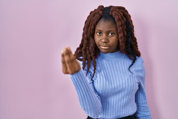 African woman standing over pink background doing italian gesture with hand and fingers confident expression