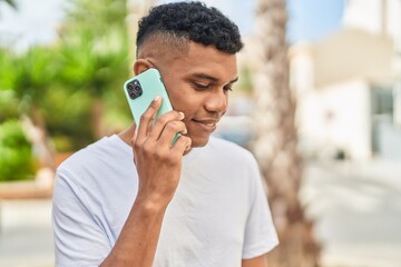 Young latin man smiling confident talking on the smartphone at street