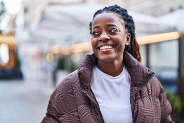 African american woman smiling confident looking to the side at coffee shop terrace