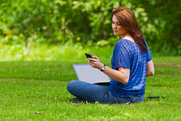 A Lovely Brunette Model Works On Her Computer Outdoor While Enjoying The Warm Weather