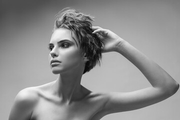 Monochrome portrait of a young attractive woman in the studio on a grey background