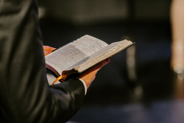 Pastor with a Bible in his hand during a sermon. The preacher delivers a speech - 570949603
