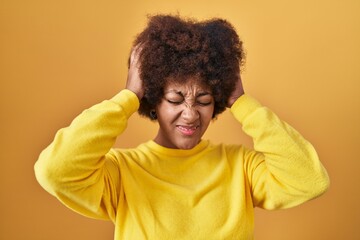 Fototapeta na wymiar Young african american woman standing over yellow background suffering from headache desperate and stressed because pain and migraine. hands on head.
