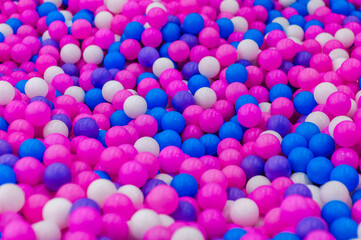 Background, closeup texture of colored, multi-colored round plastic small balls on the playground for children's games. Photo, top view, copy space.