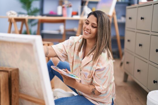 Young hispanic woman artist smiling confident drawing at art studio
