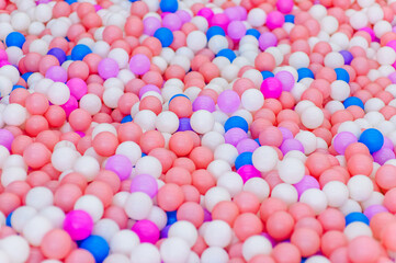 Background, closeup texture of colored, multi-colored round plastic small balls on the playground for children's games.