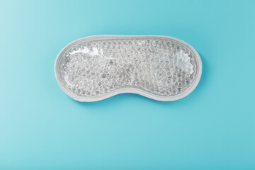 Eye mask with transparent gel balls inside on a blue background