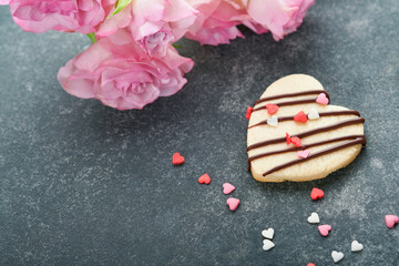 Valentines day cookies. Shortbread cookies inside sweet red heart with chocolate glaze on pink plate on grey background. Mothers day. Womans day. Sweet holidays baking. Valentines day card. Top view.