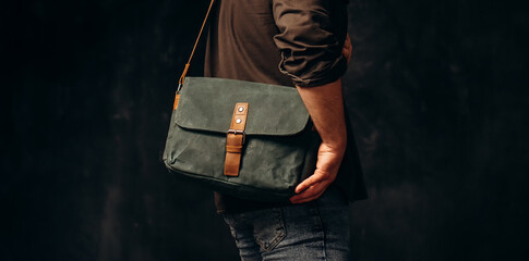 Man with duffle bag on shoulder. leather and canvas bag - obrazy, fototapety, plakaty