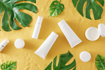 Sunscreen cosmetic concept. Flat lay composition made of cosmetic bottles without label, cream jars...
