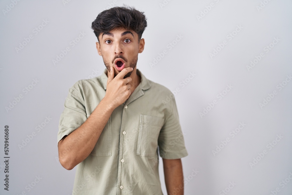 Sticker arab man with beard standing over white background looking fascinated with disbelief, surprise and a