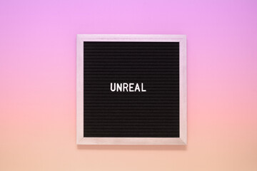 Word unreal from letters on pink background. Facts and figures true and lies concept