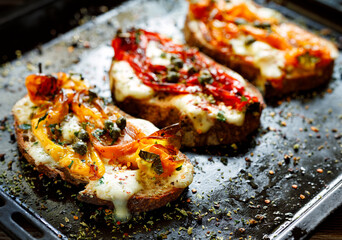 Grilled sandwiches with peppers and mozzarella cheese, focus on the first bruschetta