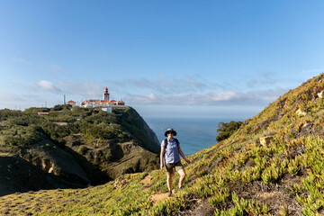 Woman hiking near Cabo Da Roca lighthouse in Sintra Mountain Range in Portgual