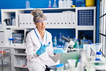 Middle age woman scientist having video call at laboratory