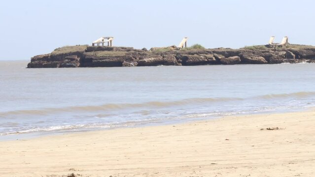 View of The Indian ocean and sand Nagaon beach with it's blue water in the distance at Diu, Gujarat, India. The brown muddy water and with a sandy beach. 4k of Arabian. wind blowing on hill and tree.