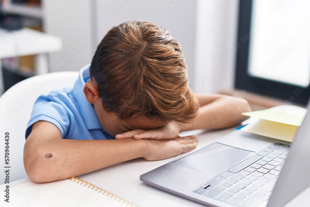 Canvas Prints Adorable hispanic boy student using computer with stressed expression at classroom