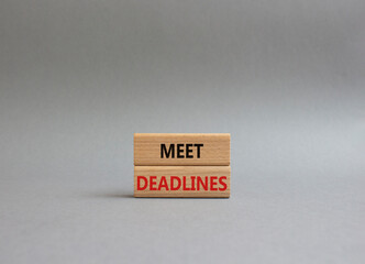 Meet Deadlines symbol. Concept word Meet Deadlines on wooden blocks. Beautiful grey background. Business and Meet Deadlines concept. Copy space