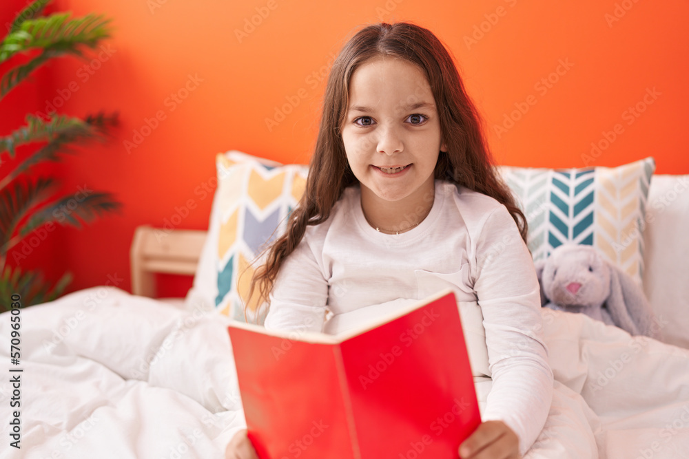 Canvas Prints adorable hispanic girl reading book sitting on bed at bedroom