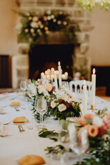 Table de dîner éclairée à la bougie devant la cheminée