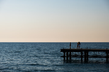 Fototapeta na wymiar Silhouettes of people on a derelict pier