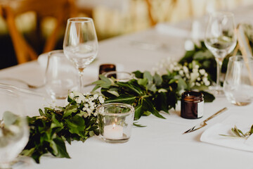 Centre de table en feuillages et bougie décorant la réception