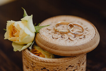 Les alliances des futurs époux posées sur leur coffret en bois