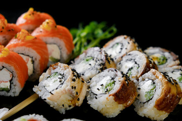 Sushi set on a black background. Fresh variety of rolls in a Japanese restaurant. Eastern cuisine.