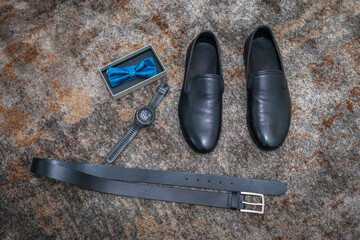 Details of the groom's wedding outfit, watch, shoes, belt, bow tie