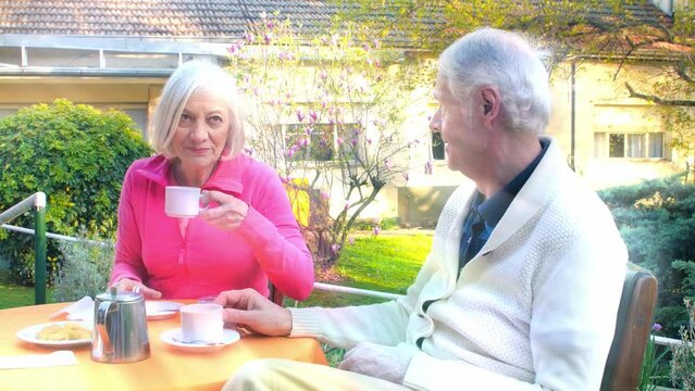 Active seniors outdoor. An elderly couple making breakfast in the garden